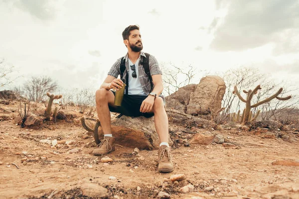 Jonge man ontspannen en genieten van de sfeer na een lange wandeling in de woestijn — Stockfoto