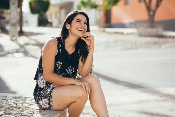 Красивая молодая женщина сидит на улице — стоковое фото