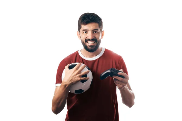 Futebol ou ventilador de futebol vestindo uniforme vermelho e segurando uma bola e um joystick no fundo branco — Fotografia de Stock