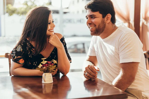 Pasangan muda jatuh cinta duduk di sebuah kafe, mengobrol dan menikmati waktu yang dihabiskan satu sama lain . — Stok Foto