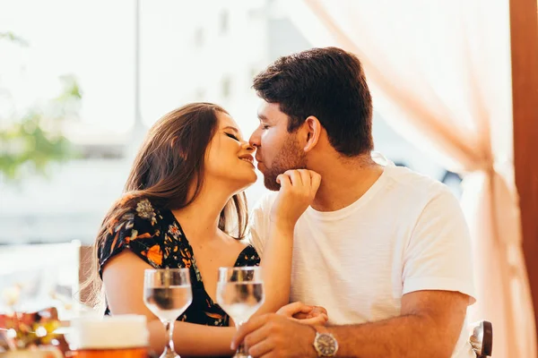 Νεαρό ζευγάρι στην αγάπη που κάθονται σε ένα καφενείο, πόσιμο νερό, έχοντας μια συνομιλία και να απολαύσετε το χρόνο που δαπανάται με το άλλο. — Φωτογραφία Αρχείου