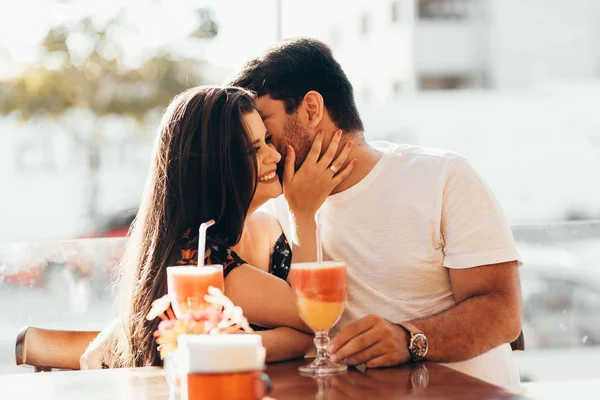 Pareja joven enamorada sentada en un restaurante, bebiendo bebida colorida, conversando y disfrutando del tiempo pasado juntos —  Fotos de Stock