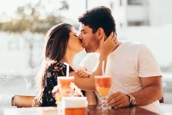 Ungt par i kärlek sitter i en restaurang, dricka färgglada drink, att ha en konversation och njuter av tiden tillbringade med varandra — Stockfoto