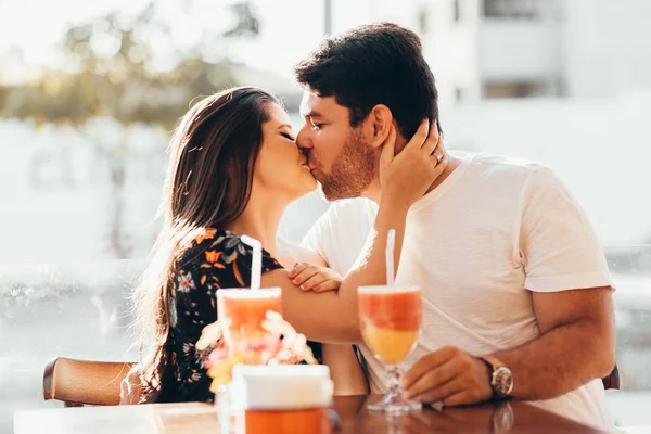 Junges verliebtes Paar sitzt in einem Restaurant, trinkt ein buntes Getränk, unterhält sich und genießt die Zeit miteinander — Stockfoto