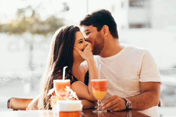 Pareja joven enamorada sentada en un restaurante, bebiendo bebida colorida, conversando y disfrutando del tiempo pasado juntos —  Fotos de Stock