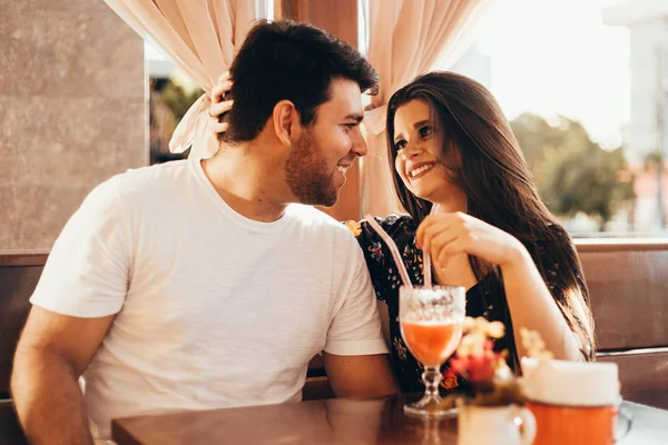Młoda para zakochanych siedzi w restauracji, filiżance kolorowy napój, po rozmowie i czas spędzony ze sobą — Zdjęcie stockowe