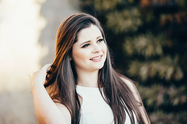 Portret van gelukkig lachende vrouw staande op het plein op de zonnige zomer of lente buiten, schattige lachende vrouw, aantrekkelijke jonge meisje geniet van de zomer Stockfoto