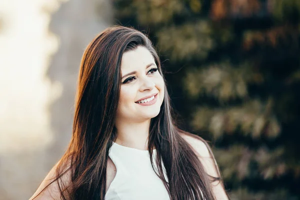 Portret van gelukkig lachende vrouw staande op het plein op de zonnige zomer of lente buiten, schattige lachende vrouw, aantrekkelijke jonge meisje geniet van de zomer Stockafbeelding