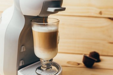 Ahşap arka plan üzerinde espresso macchiato ve kahve makinesi