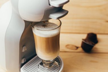 Ahşap arka plan üzerinde espresso macchiato ve kahve makinesi