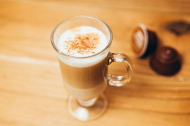 Fincan espresso macchiato kahve ve ahşap arka plan üzerinde kapsül