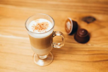 Fincan espresso macchiato kahve ve ahşap arka plan üzerinde kapsül