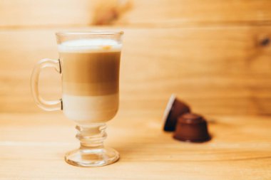 Fincan espresso macchiato kahve ve ahşap arka plan üzerinde kapsül