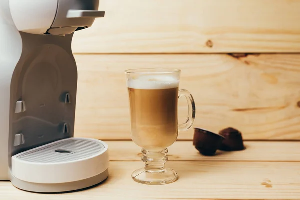 Espresso macchiato and coffee machine on wooden background — Stock Photo, Image