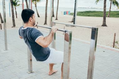 Yakışıklı genç adam sahilde sokak egzersiz yapıyor