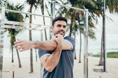 Yakışıklı genç adam sahilde sokak egzersiz yapıyor