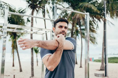 Yakışıklı genç adam sahilde sokak egzersiz yapıyor