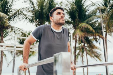 Yakışıklı genç adam sahilde sokak egzersiz yapıyor