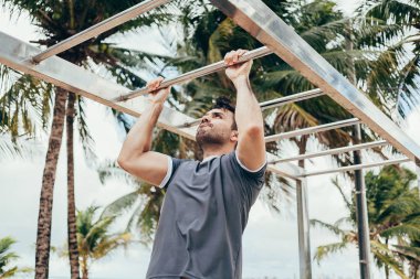 Yakışıklı genç adam sahilde sokak egzersiz yapıyor