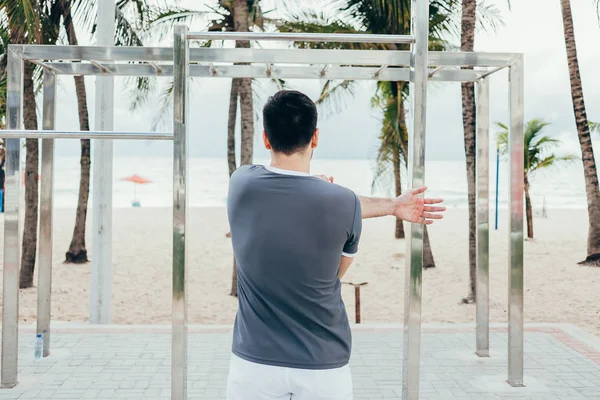 Красивий молодий чоловік робить вуличні тренування на пляжі — стокове фото