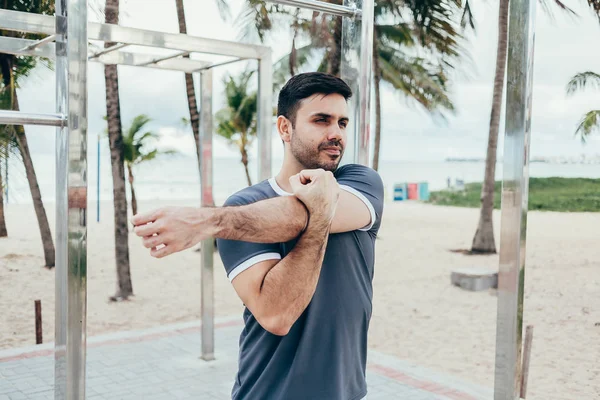 Stilig ung man gör gatan träning på stranden — Stockfoto