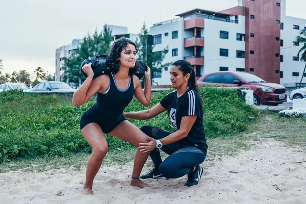 Cabedelo, 파라이바, 브라질-2018 년 4 월 26 일-개인 트레이너는 비치 운동에 클라이언트를 지원합니다. — 스톡 사진