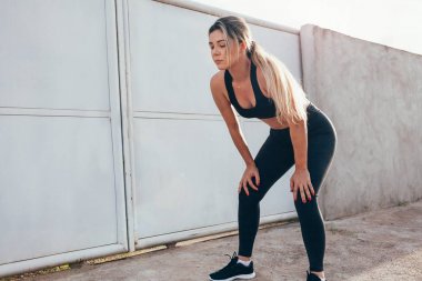 Yorgun kadın runner zor çalıştırdıktan sonra bir dinlenme alarak