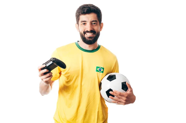 Futebol brasileiro ou fã de futebol vestindo uniforme amarelo e segurando uma bola e um joystick no fundo branco — Fotografia de Stock