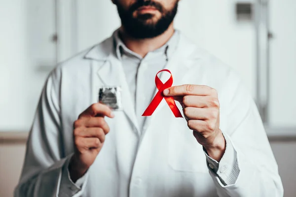 HIV hastalığı için kırmızı kurdele. Doktorun elinde farkındalık. 1 Aralık Dünya AIDS Günü konsepti.. — Stok fotoğraf