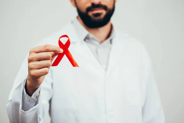 Nastro rosso per la consapevolezza della malattia da HIV nelle mani del medico, 1 dicembre Concetto della Giornata Mondiale dell AIDS . — Foto Stock