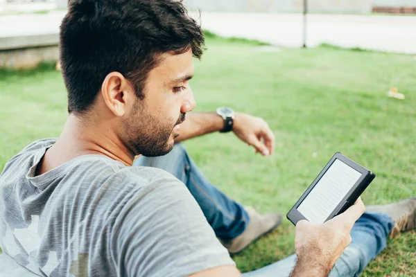 Jovem lendo e-book no parque — Fotografia de Stock