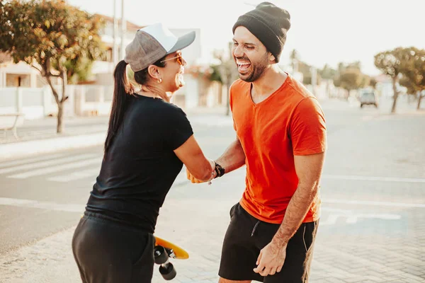 Skater homem e mulher apertando as mãos ao ar livre — Fotografia de Stock