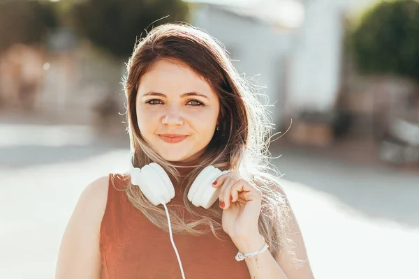 Szabadtéri portré fiatal nőről, aki zenét hallgat fejhallgatóval az utcán — Stock Fotó