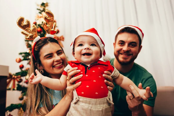 Jovem família celebrando o Natal em casa. Feliz jovem família desfrutando de seu tempo de férias juntos . — Fotografia de Stock