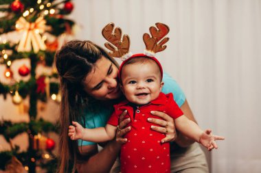 Anne ve bebeği Noel tatilinde evde oynuyorlar.