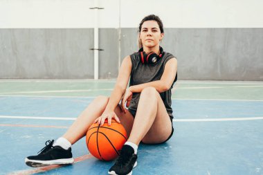 Genç bayan basketbolcu yerel bir sahada antrenman yapıyor.