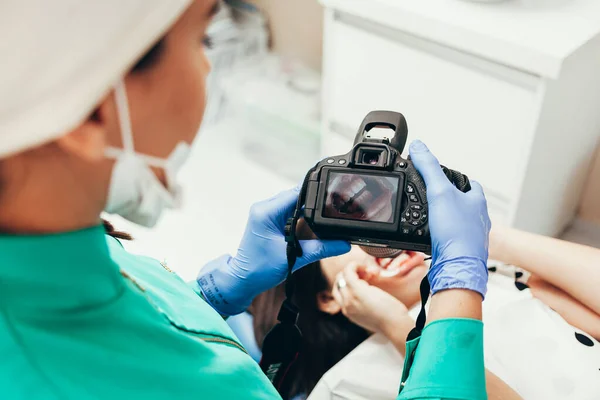 Mujer dentista con cámara haciendo tomas de la boca de su paciente — Foto de Stock