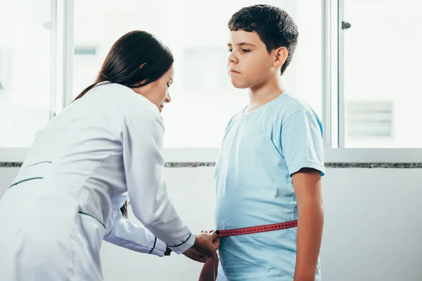 Dokter wanita mengukur anak gemuk di klinik. — Stok Foto