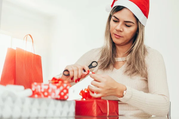 Christmas santa woman preparing gifts wrapping paper for holidays