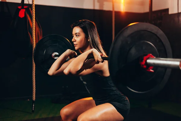 体操馆的肌肉发达的女人在做重体能运动. 年轻女人 — 图库照片