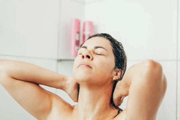 Jovem mulher lavando o cabelo com shampoo no chuveiro — Fotografia de Stock