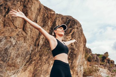 Yürüyüşçü dağa tırmanırken manzarayı seyrediyor.