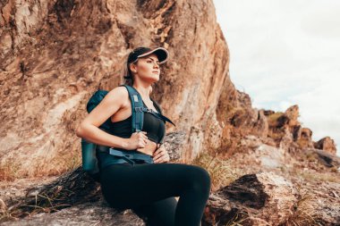 Yürüyüşçü dağa tırmanırken manzarayı seyrediyor.