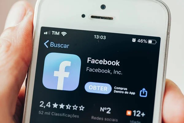 Campina grande, paraiba, brasilien - 27. November 2019. man hält iphone und sieht Apple Store Bildschirm der App facebook — Stockbild Campina grande, paraiba, brasilien - 27. November 2019. man hält iphone und sieht Apple Store Bildschirm der App facebook — Stockfoto