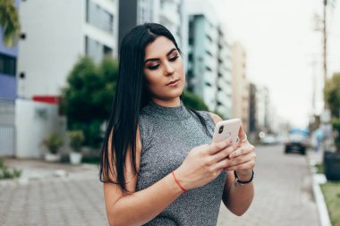 Şehirde akıllı telefon kullanan ciddi bir yüz ifadesi olan portre