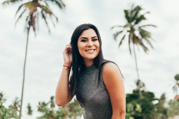 Portret van een elegante vrouw buiten met palmbomen op de achtergrond — Stockfoto