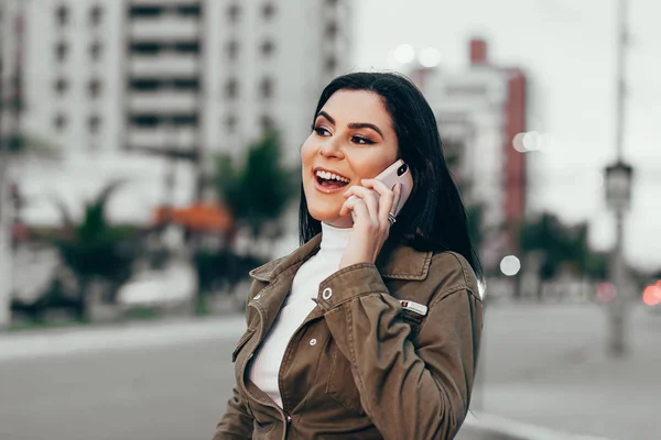 Усміхнена жінка використовує смартфон у місті — стокове фото