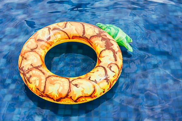 Ananasbecken schwimmt, Ring schwimmt in einem erfrischenden blauen Pool — Stockfoto