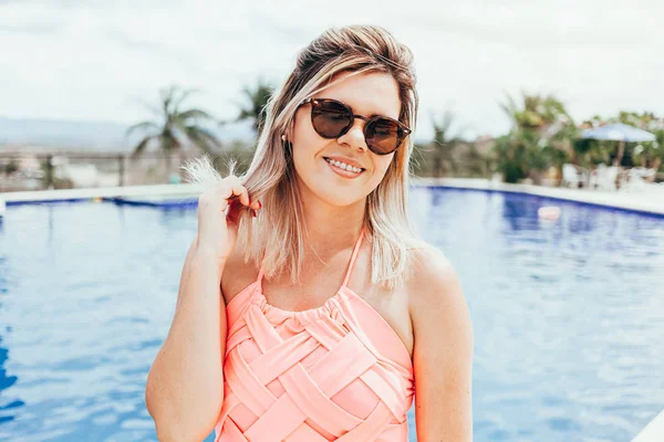 Porträt einer jungen lächelnden Frau mit blauem Pool im Hintergrund — Stockfoto