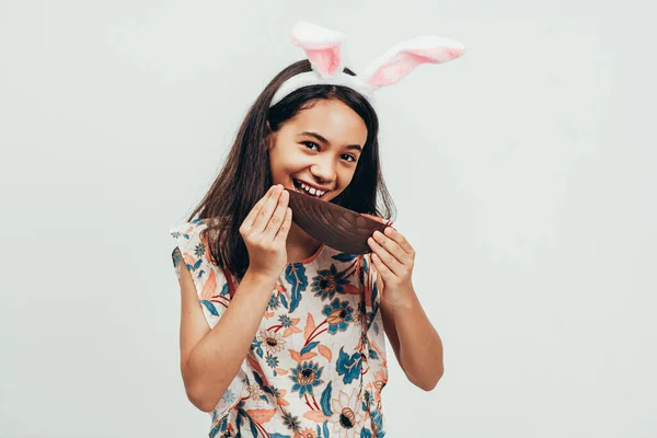 Sweet Little Girl Wearing Bunny Ears Eating Chocolate Easter Egg — Stock Photo, Image